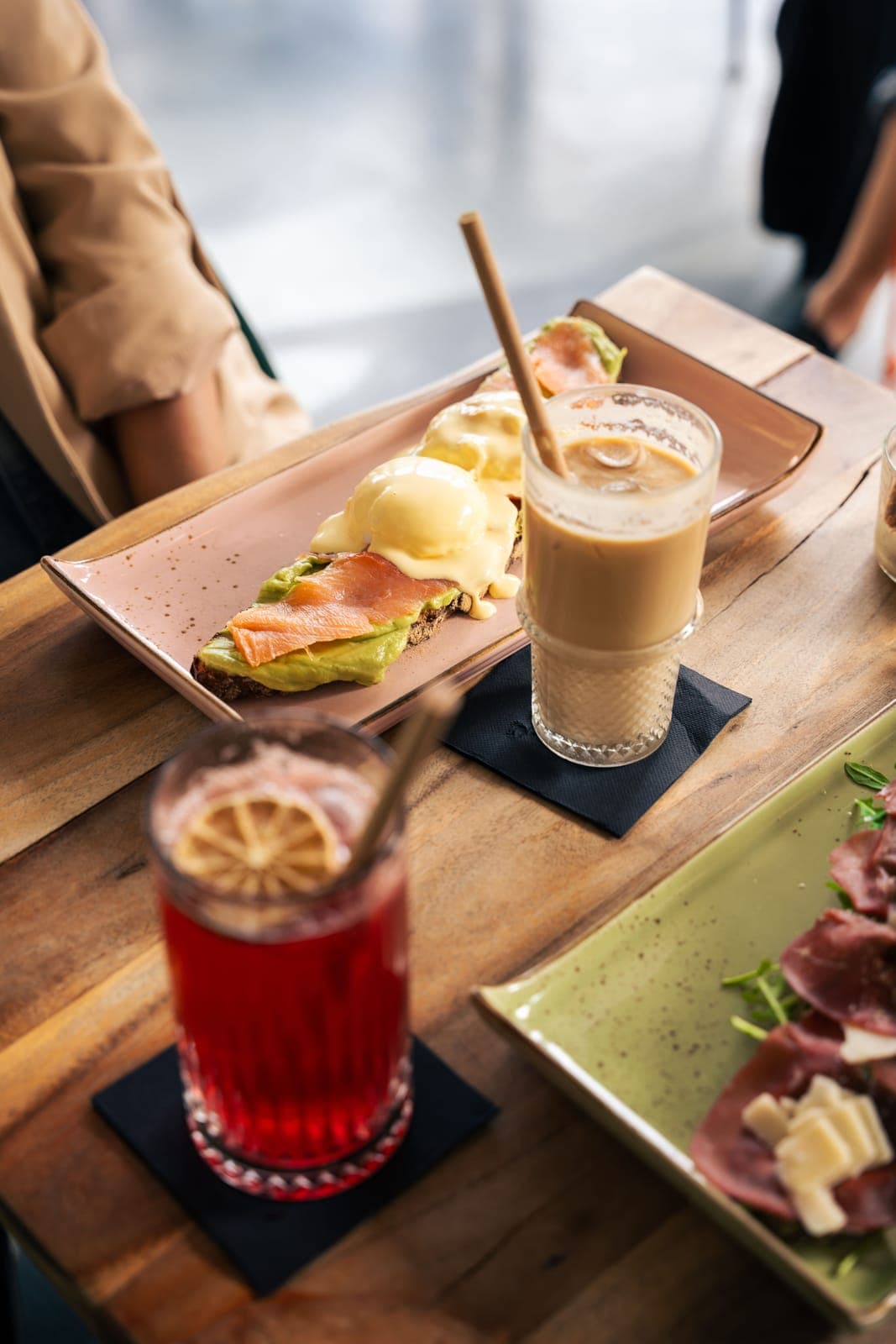 Gedeckter Tisch mit pochierten Eiern, Lachs, Iced Latte und Limonade